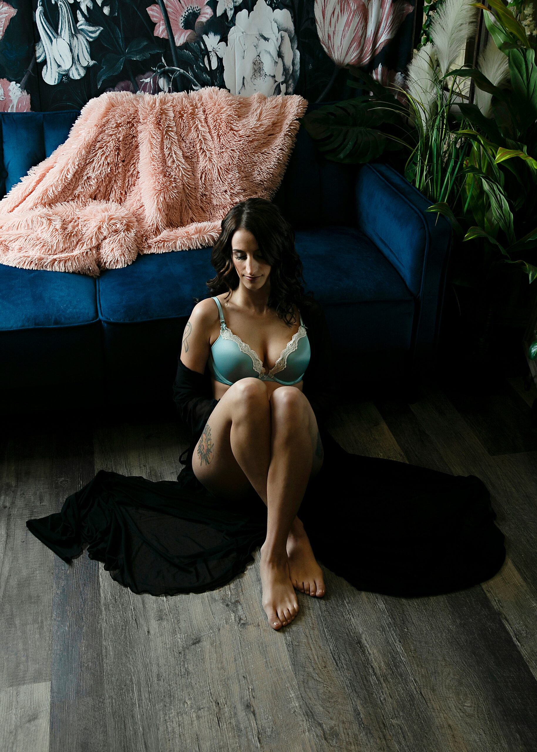 A woman in a green bra sits on the floor of a studio against a blue couch before some milwaukee date night ideas